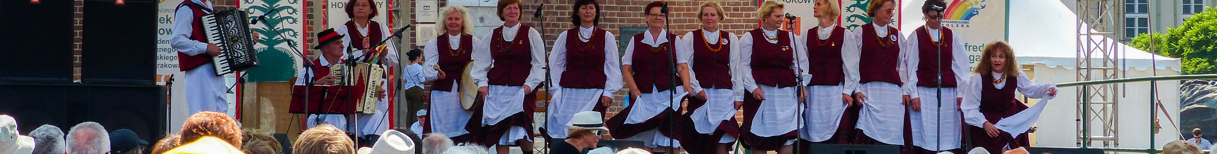 A women's choir dressed in traditional garb performs on stage at the market place at Rynek Glowny, the main square in Krakow, Poland.