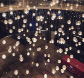 Floating lights over a table covered in a red tablecloth that says "Writer's Digest."
